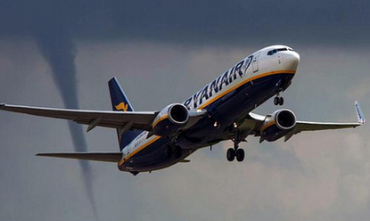 Photo captures passenger plane taking off just as a tornado prepares to touch down