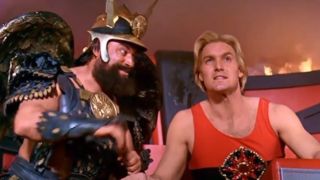 Sam J. Jones in a red A-shirt sitting beside Brian Blessed in Flash Gordon