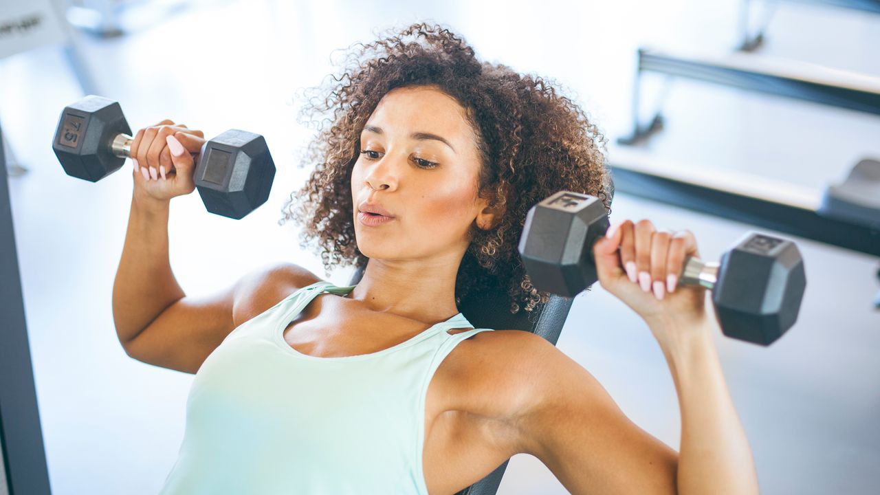 Woman training her upper body using a pair of dumbbells