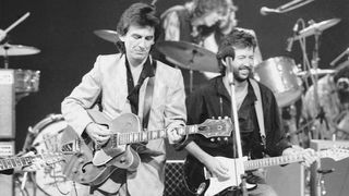 George Harrison (1943 - 2001, left) and Eric Clapton at Limehouse Studios in London during recording of the TV programme 'Blue Suede Shoes', spotlighting veteran rockabilly songwriter and guitarist Carl Perkins. In the background are drummers Slim Jim Phantom and Ringo Starr