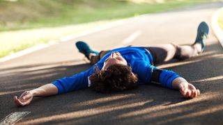 Exhausted runner lying on road