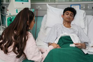 Priya Nandra-Hart holds Nugget Gulati's hand in his hospital bed.