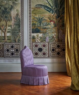 Lilac silk skirted chair in front of decorative wallpaper with yellow silk curtain and wood floors