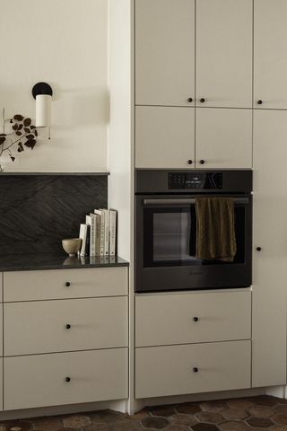 A white kitchen with dark black backsplash tiling