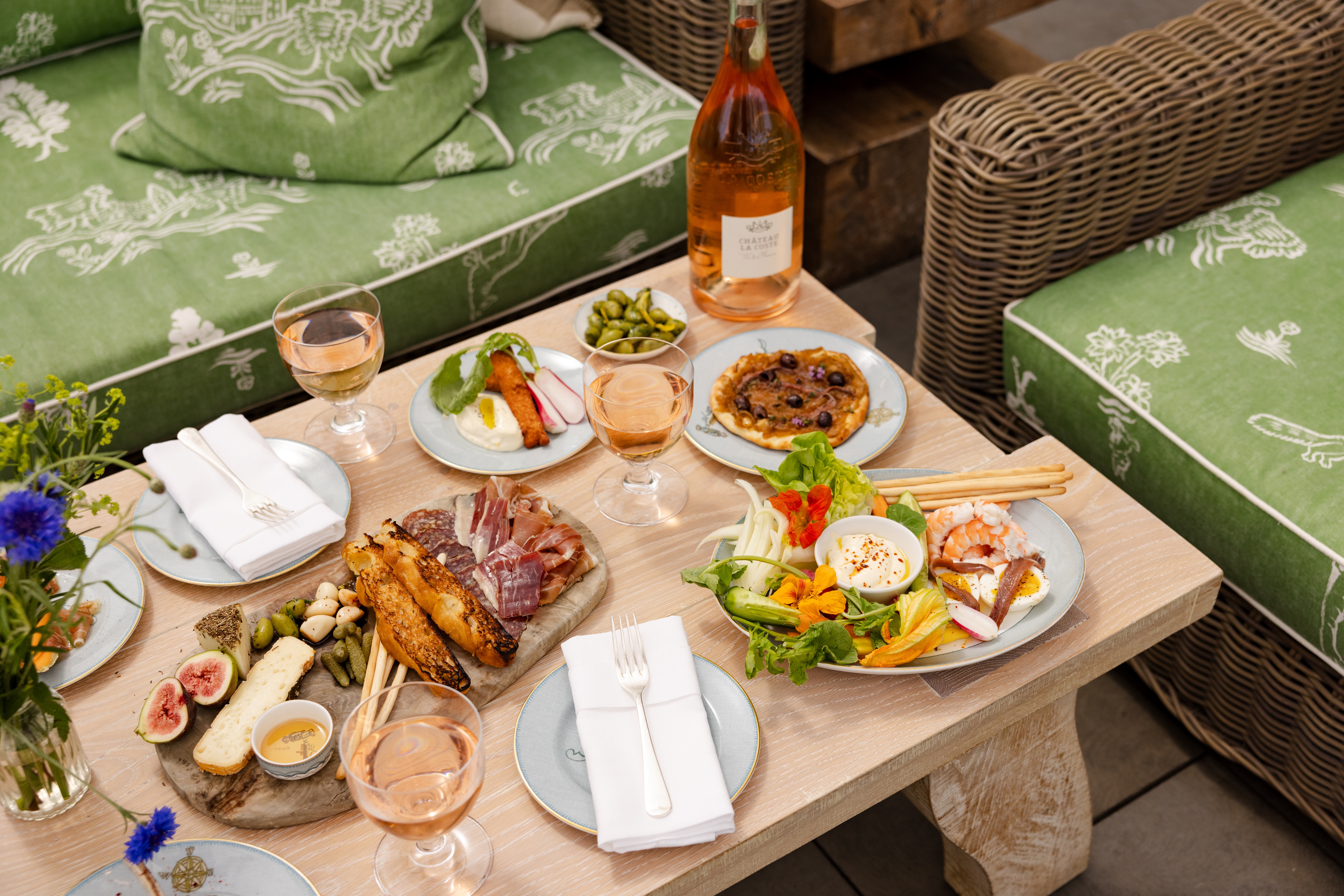 A charcuterie and crudités board on a bare wooden table