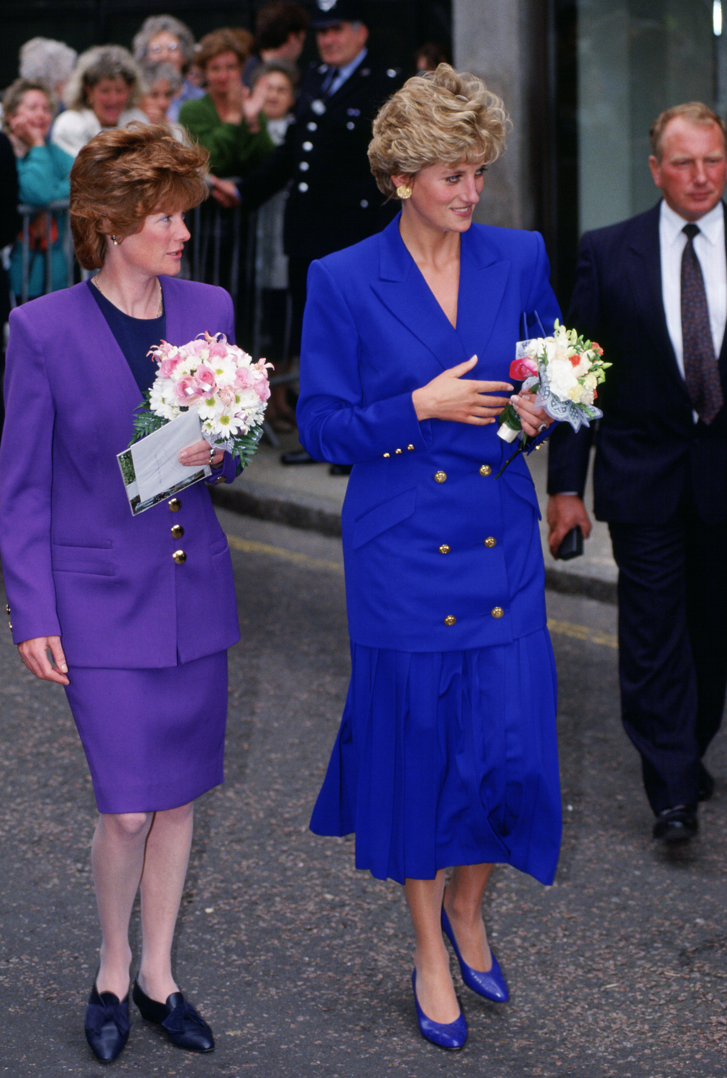 Princess Diana wearing a blue dress walking next to her sister Sarah McCorquodale