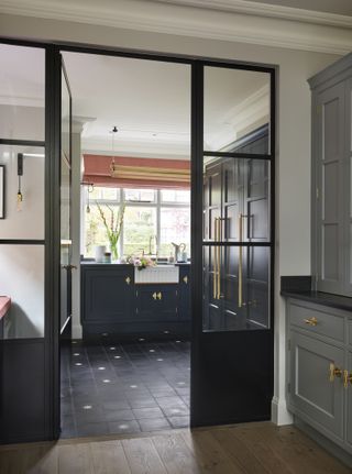 Double doors opening out into a dark utility room.