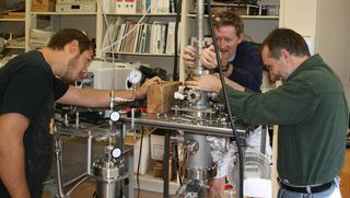 Northern Arizona University's ice lab researchers Matt Bovyn (left), Stephen Tegler (center) and Will Grundy (right) modify the machinery they use to generate exotic ices like those found on Pluto.