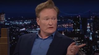 Conan O'Brien on The Tonight Show pointing and looking to his right. 