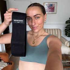 Health writer Georgia Brown trying side stepping workouts at home - in matching green gym gear and with a workout mat, resistance band and weights