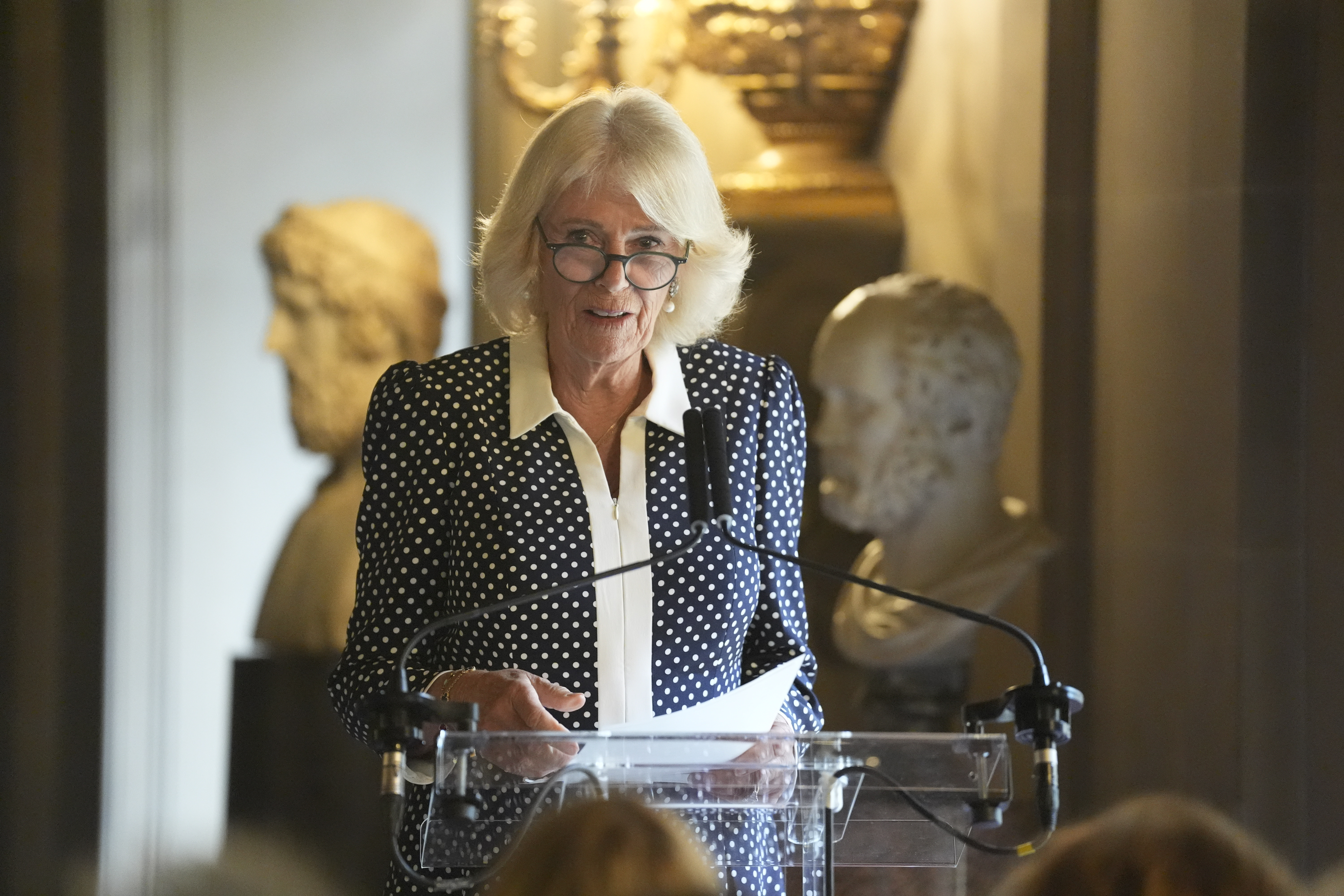 Queen Camilla wearing a polka dot dress and talking about Mr Darcy from Pride and Prejudice