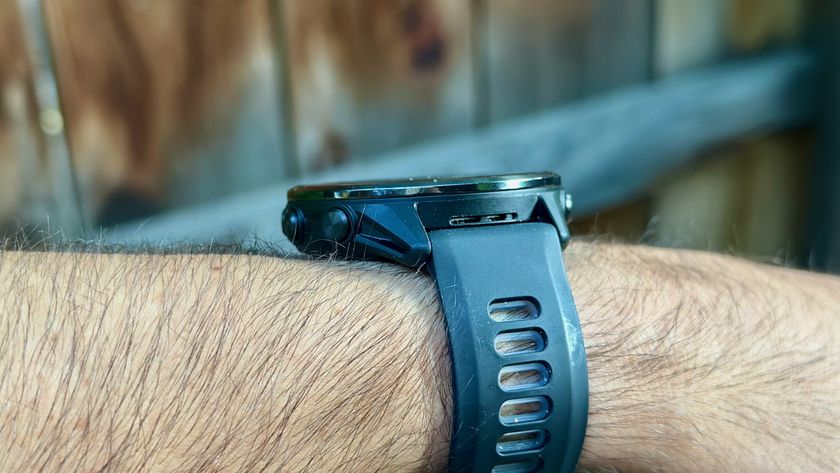 The Garmin Forerunner 970 worn on a wrist at a side angle showing its black titanium bezel, polymer case, and silicone band.