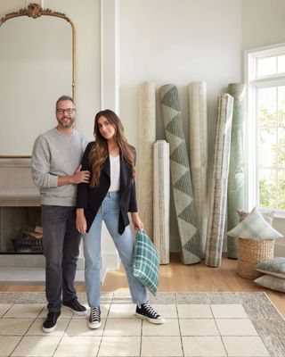 chris loves julia standing next to their rug collection with loloi