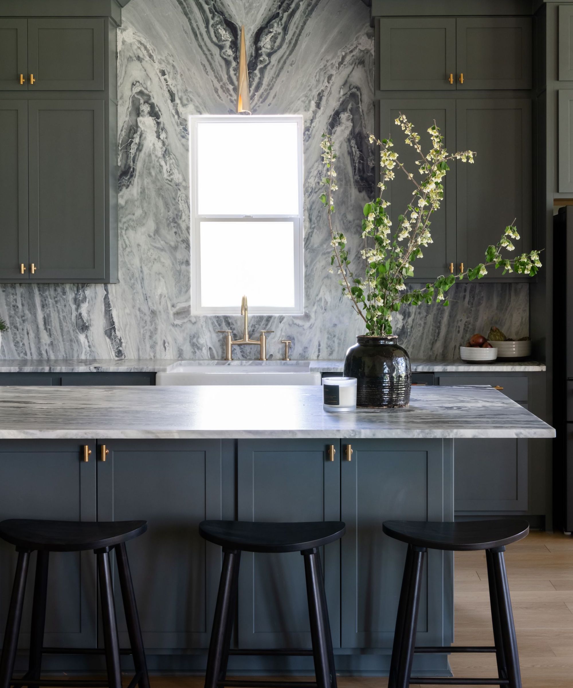 kitchen with dramatic stone clad walls and dark cabinetry