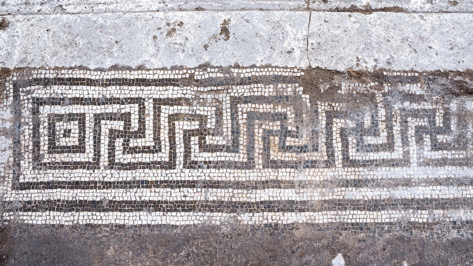 archaeologists work at an ancient Roman site revealing mosaic floors and frescoed walls of a villa