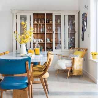 exterior of scandi house dining area with glazed dresser chair and throw