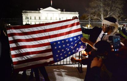 Protesters try unsuccessfully to burn an American flag.