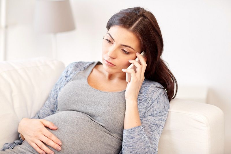 A pregnant woman on the phone.