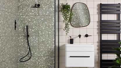bathroom with a terrazzo tiled shower, organic shaped mirror and matt black hardware