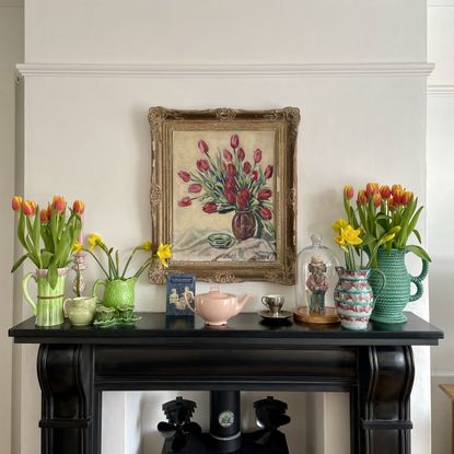 black fireplace with vintage vases and flowers on the mantlepiece