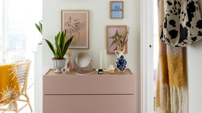 Console table storing books and decorative items with lamp and vase displayed on top