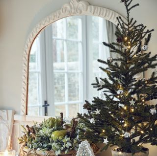 white framed mirror with Xmas tree in front