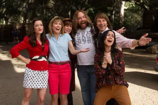 a group of people wearing 80s close hug and reunite in wet hot american summer 10 years later