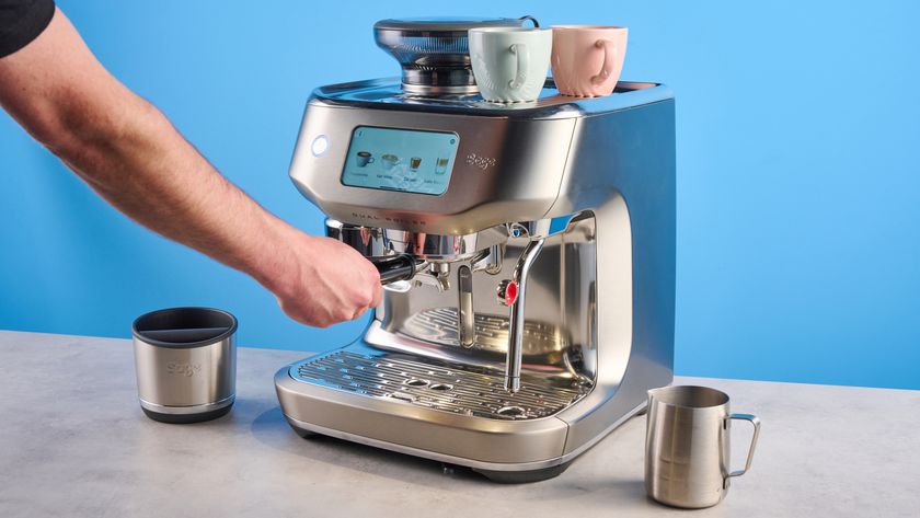 the breville oracle dual boiler / sage oracle dual boiler in stainless steel, showing its touchscreen, steam wand, built in grinder, and espresso shots