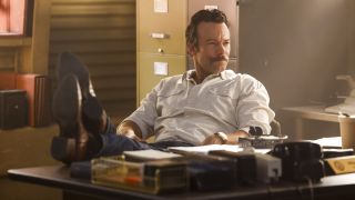 Kyle Schmid's Mike Franks sitting at desk with his legs propped up in NCIS: Origins