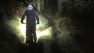 A rider seen from the rear riding the YT Jeffsy Core 4 at night