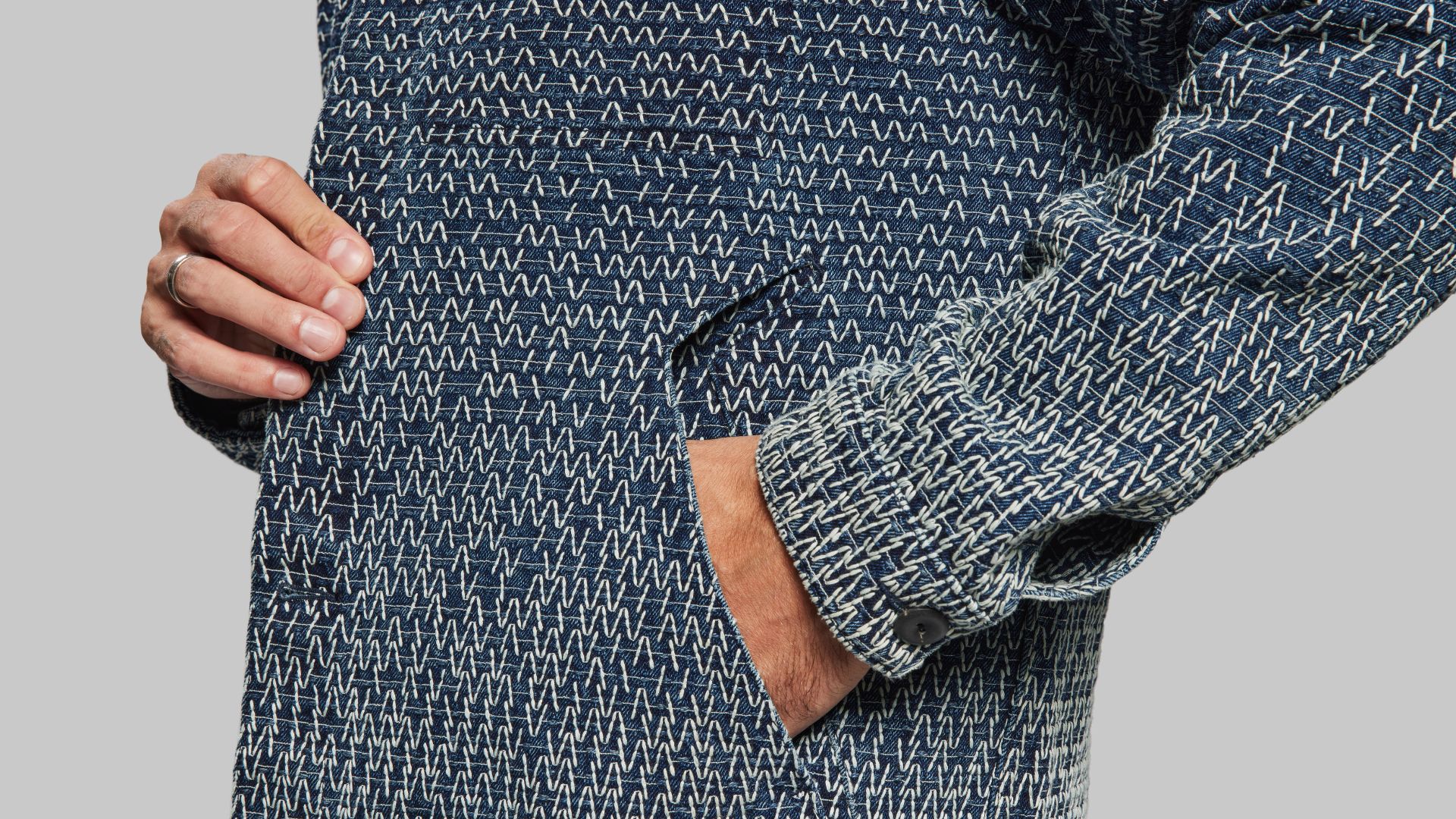 an image of a side pocket in a man&#039;s coat with a blue and white stitching design