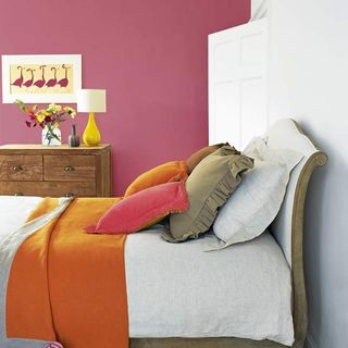 bedroom with pink wall and bed with pillows