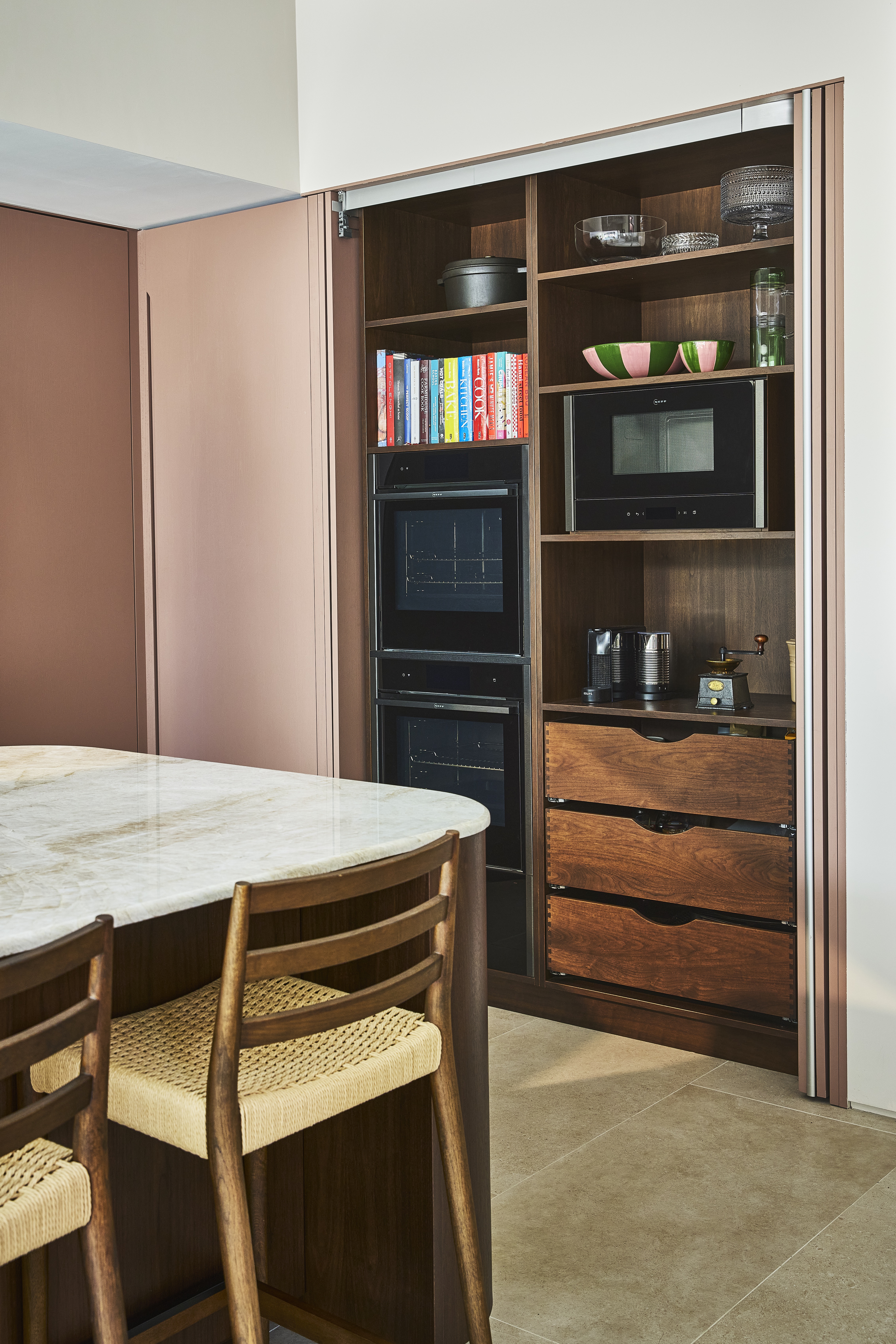 open kitchen cabinets with pocket door and wooden drawers behind
