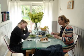Kate Winslet and Mia Threapleton sat at a dining table in I Am Ruth
