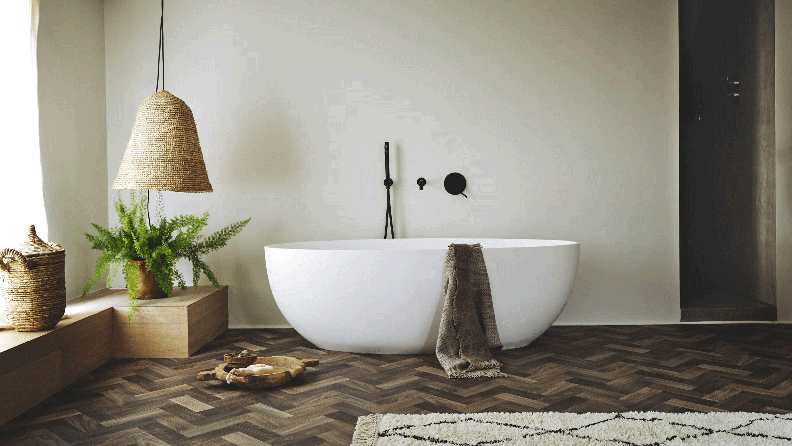 Freestanding bath in bathroom with vinyl herringbone style flooring