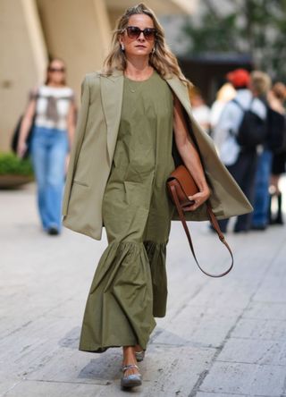 A woman wearing a khaki maxi dress with an oversized blazer in New York.