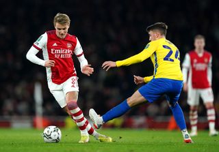 Arsenal’s Martin Odegaard (left) and Sunderland’s Dan Neil battle for the ball during the Carabao Cup quarter final match at the Emirates Stadium, London. Picture date: Tuesday December 21, 2021