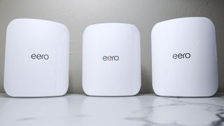 A three-pack of the eero Max 7 mesh router on a desk