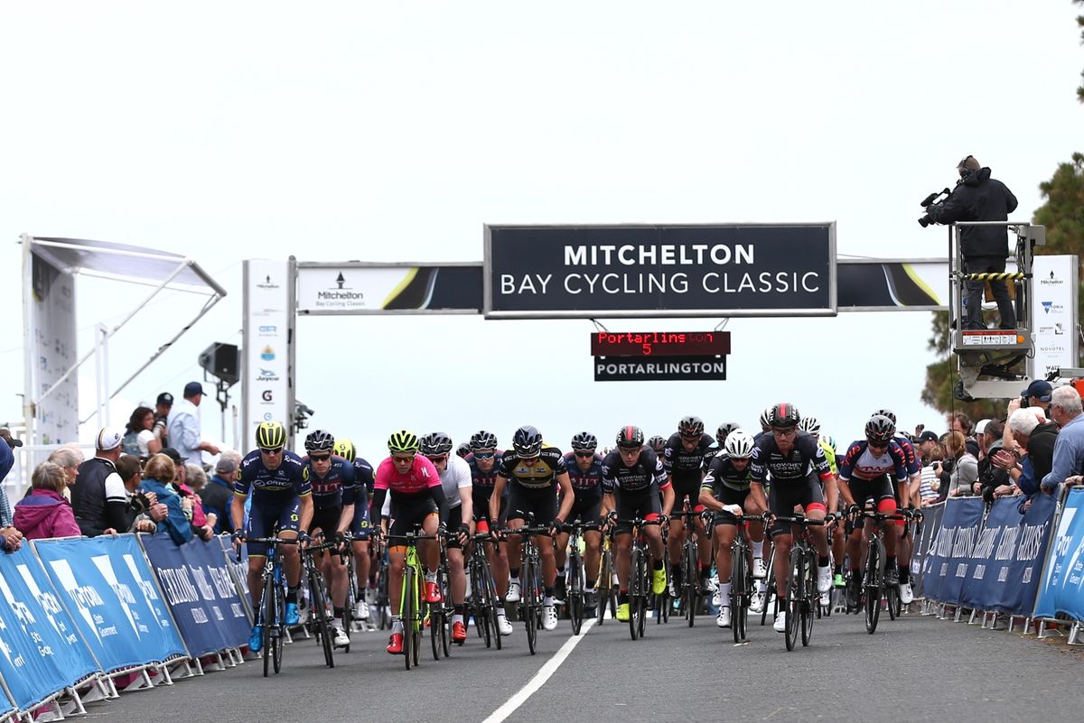 The peloton comes through under the start/finish line