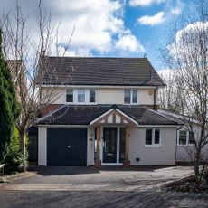 White double story house with black roof.