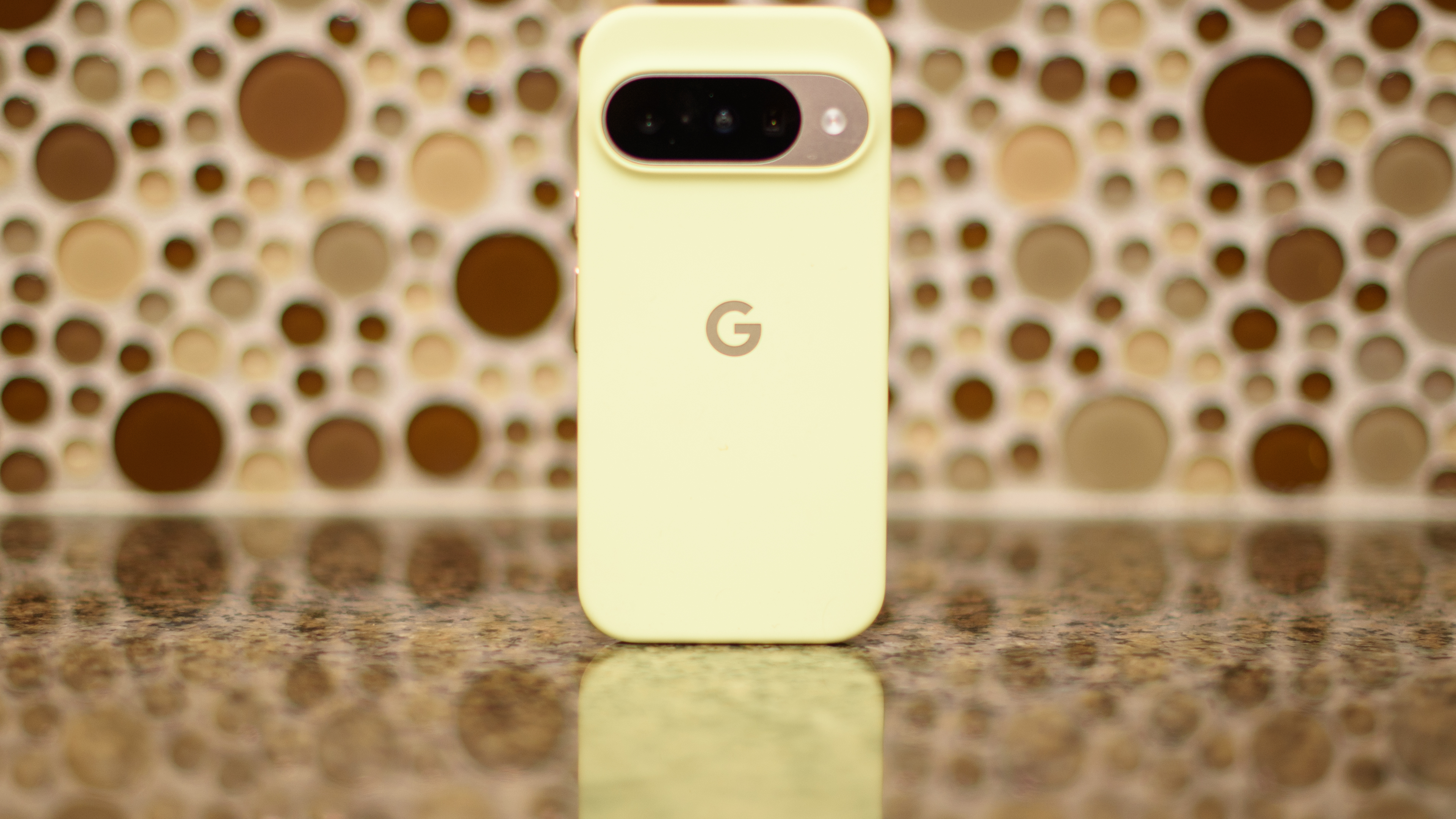 Google Pixel 10 in Lemongrass against a bubbly backsplash