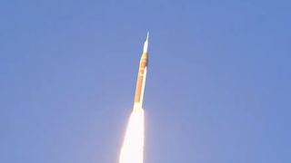 a rocket launches above a plume of fire