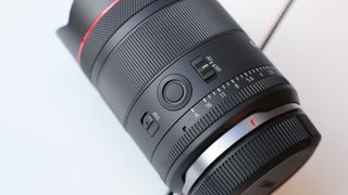 Close up of the buttons on a Canon RF 14mm f/1.4L VCM lens on a windowsill