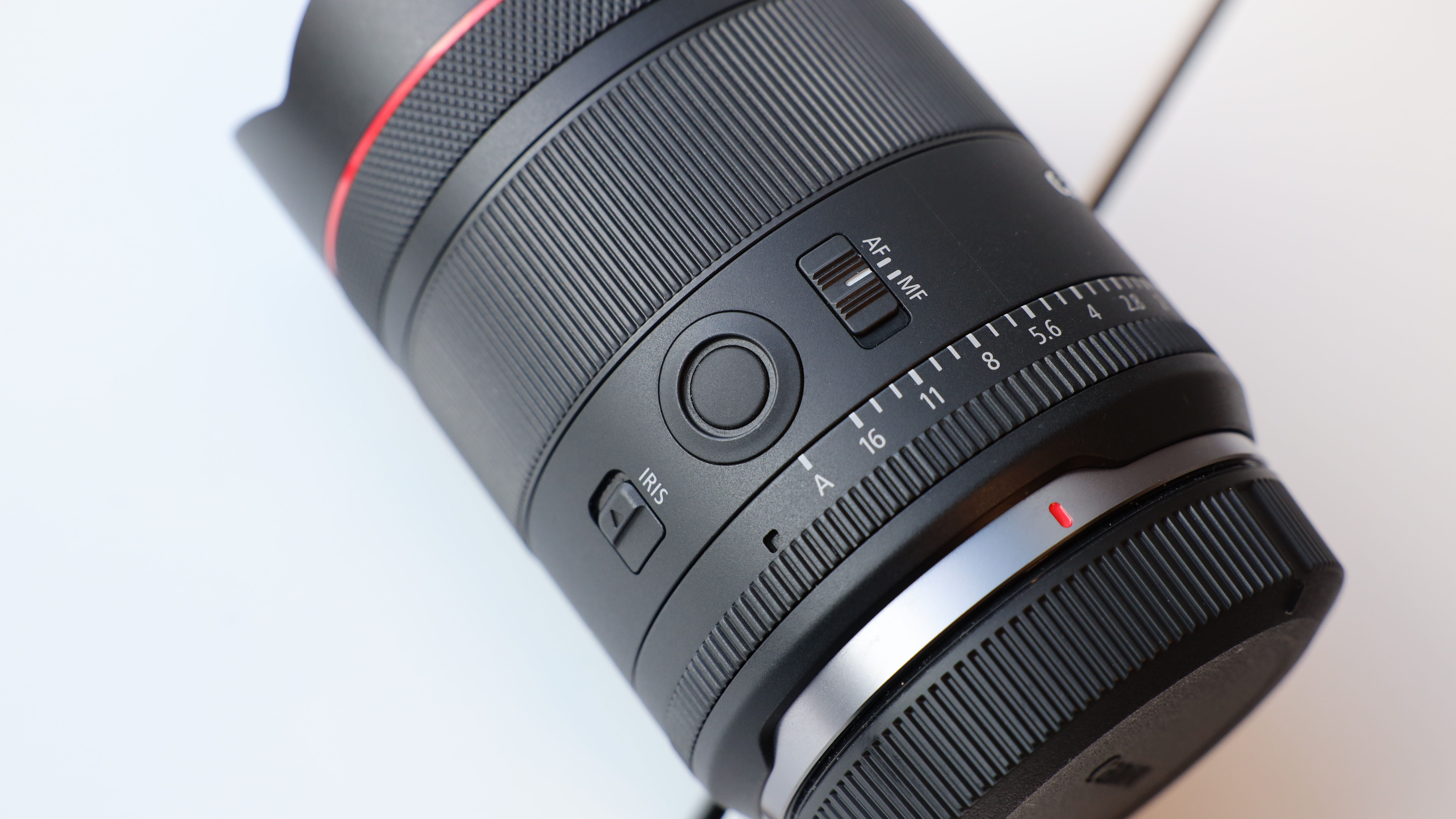 Close up of the buttons on a Canon RF 14mm f/1.4L VCM lens on a windowsill