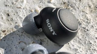 Närbild på en Sony WF-C500-hörlur