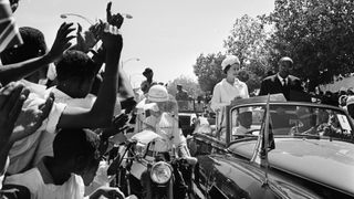 Cheering Ethiopians line the route as Queen Elizabeth II and President Dr El Tieani El Mahi drive past in an open car during a royal tour of the Sudan by the Queen and the Duke of Edinburgh.