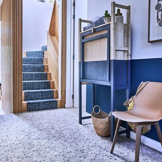 Grey-blue carpet on floor with blue patterned stair case runner on wooden stair case
