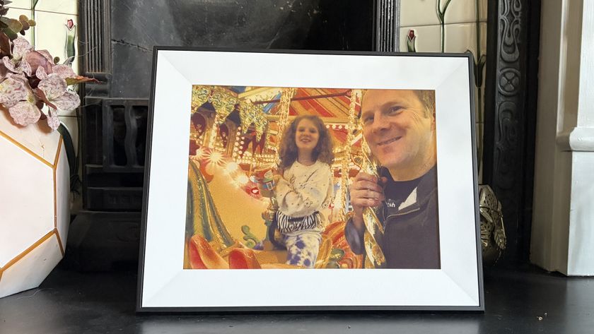Aura Ink digital photo frame displaying a picture of a man and child at a fairground