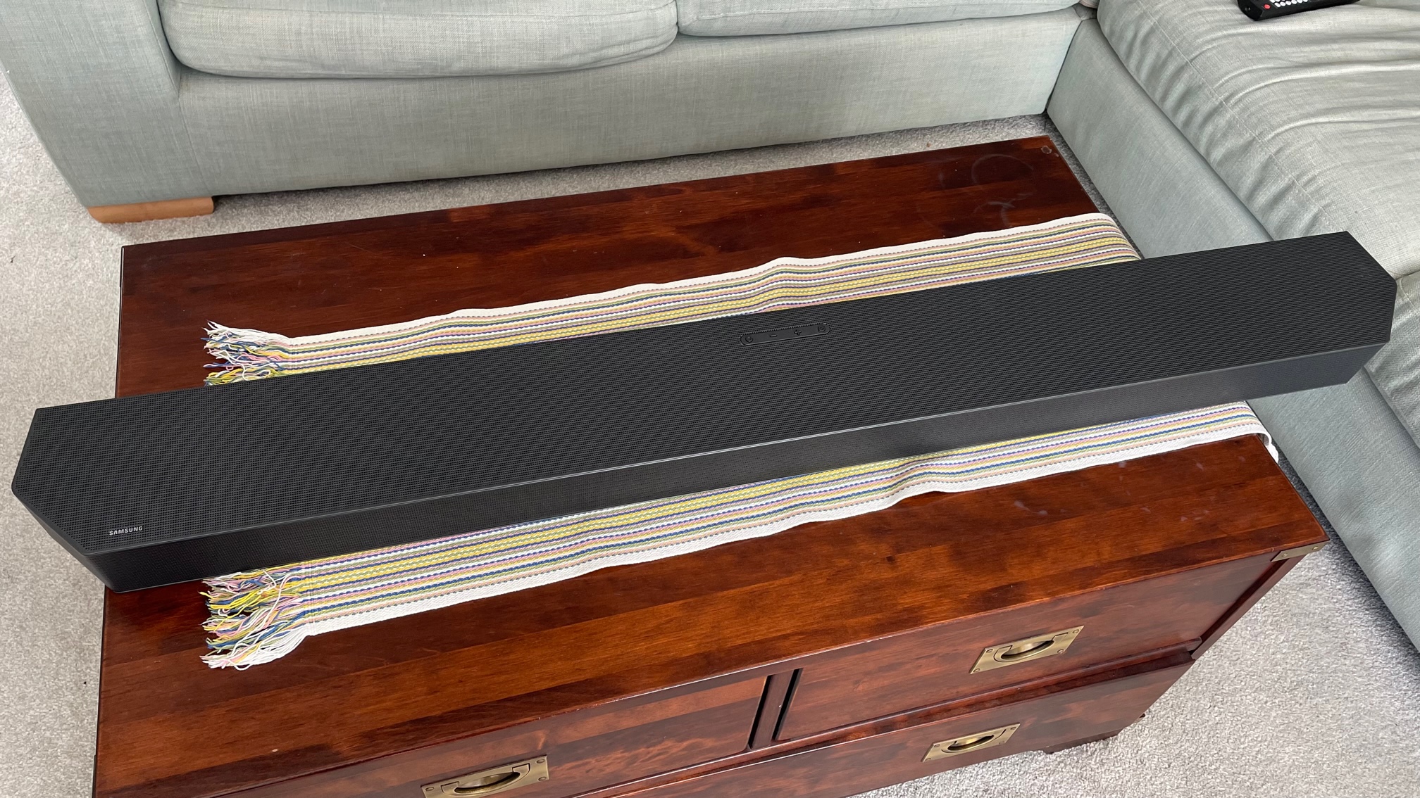 The soundbar part of the Samsung HW-Q990C pictured from above on a wooden table.