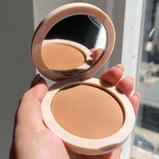 junior shopping editor Amelia holding the Jones Road bronzer in shade Tan